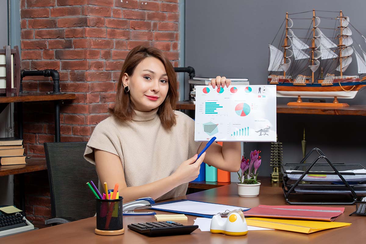 front view pretty woman showing diagrams working in office
